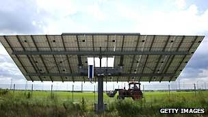 A tractor drives past a solar panel, outside the EQ-SYS factory that makes rotating frames for solar panels, in Feldheim, Brandenburg, Germany