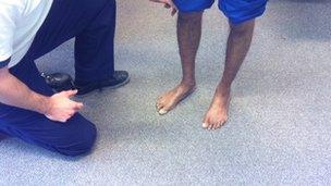 Physiotherapist examines man's ankles