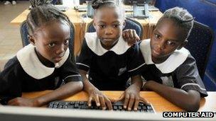 Girls using a computer donated by Computer Aid