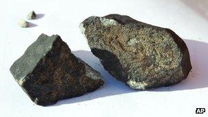 The meteorite which fell through the roof of a shed in Oslo. It is broken in two pieces and is grey.