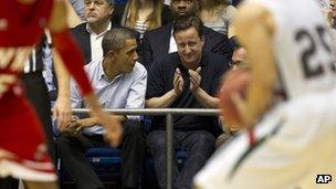 Barack Obama and David Cameron talk during a NCAA basketball game 13 March 2012