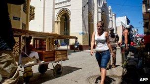 Cubans walk next to Our Lady of Charity church, occupied by 13 Cuban dissidents on 14 March, 2012