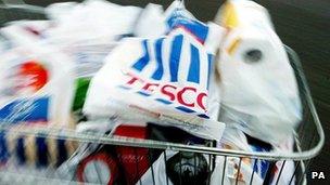 A shopper packs a car with shopping at a Tesco store