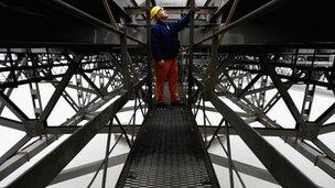 A workman with a hard hat standing on the Forth road bridge.