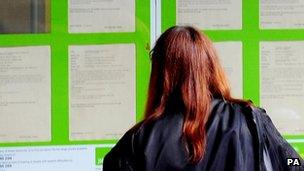 Woman looking into the window of a job centre