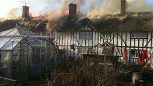 Thatched cottages on fire