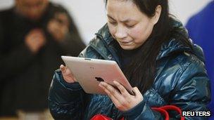 A customer tests out an Apple iPad at an Apple Store in downtown Shanghai, China 1 March 2012