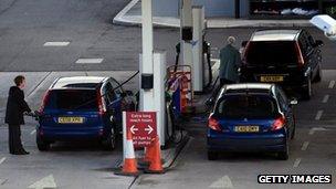 Motorists fill up their cars with petrol and diesel at a supermarket filling station in the UK, March 2012