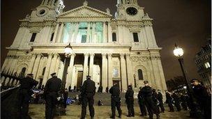 Riot police stand guard as they prepare to remove protesters from the Occupy encampment in front of St Paul's Cathedral