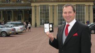 Mike Curtis with his medal outside Buckingham Palace