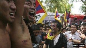 Tibetan activists tend to man who set himself alight (out of picture at bottom) in Delhi - 26 March 2012