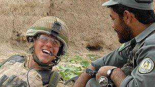 A Guardsman of the 1st Battalion the Coldstream Guards shares a joke with a member of the Afghan National Police