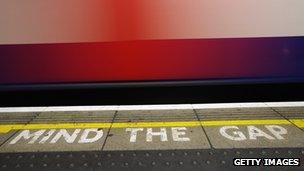 Tube train passes Mind the Gap sign