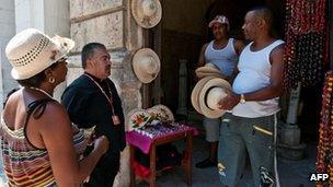 Pilgrims buy handicrafts before attending a mass at the Catedral of Havana on 27 March 2012