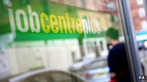 A man looks in the window of a job centre