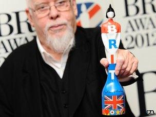 Sir Peter Blake holding this year's Brit award which he designed