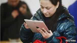 A woman tries out an iPad at an Apple stores in China