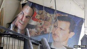 A damaged picture of the late Hafez al-Assad and his son, President Bashar al-Assad, in a police building damaged by an explosion in Damascus (17 March 2012)