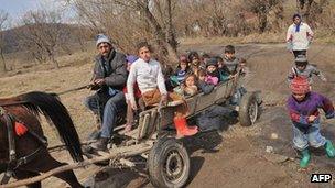 Roma children are taken home from school on a horse and cart north of Bucharest, 28 March 2012