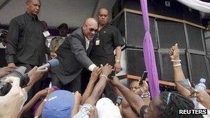 Suriname's President Desi Bouterse greets supporters that have gathered in front of Parliament in Paramaribo March, 23, 2012.