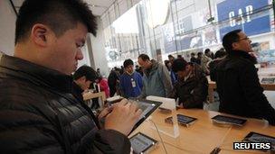 A man tests out an iPad at an Apple shop in Shanghai, 28 February 2012