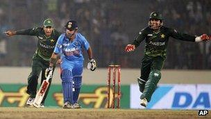 Pakistan's Umar Akmal, right, and Nasir Jamshed, left, celebrate the dismissal of India's Gautam Gambhir, center, during their Asia Cup cricket match in Dhaka, Bangladesh, Sunday, March 18, 2012.