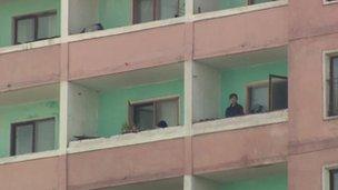 Woman on a balcony of tower block, 9 April 2012