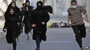 Bahraini anti-government protesters run from riot police who dispersed a rally in Sanabis, on the edge of the capital of Manama, in support of jailed activist Abdulhadi al-Khawaja (9 April 2012)