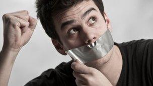 Man with tape over his mouth (stock picture)