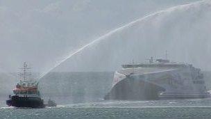 Condor being given a celebratory water salute by the States tug