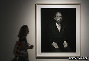 Woman walking past photograph of Emperor Hirohito