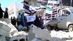 Demonstrators with the Syrian opposition flags protest against Syria's President Bashar Al-Assad after Friday prayers in Al Qasseer city, near Homs April 13, 2012