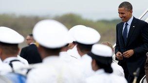 US President Barack Obama walks through an honor cordon upon arrival on Air Force One at Rafael Nunez International Airport in Cartagena, Colombia on April 13, 2012