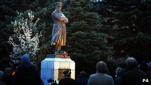 People gather at a statue of Commander Edward John Smith, captain of the Titanic