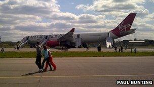 Passengers disembark the plane
