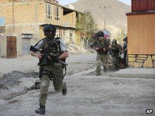 NATO soldiers run during a gun battle in Kabul