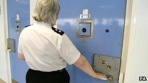 A woman opening a door in a prison