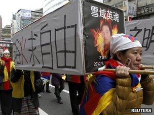 Activists carrying mock-ups of coffins to mourn for those who killed themselves in self-immolation