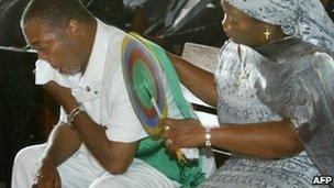 Charles Taylor is comforted by his wife, Jewel Howard-Taylor, at the funeral of his mother, Yassa Zoe Taylor, 22 July, 2003 in Monrovia, Liberia