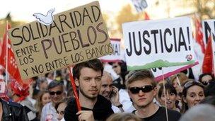 Spaniards hold placards calling for justice during a general strike