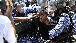 Riot policemen detain a supporter of former President Mohamed Nasheed during a protest near the parliament against President Mohammed Waheed Hassan, 19 March 2012