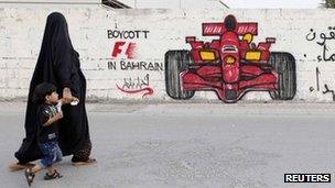 A woman and boy walk past graffiti urging the boycott of the 2012 Bahrain Grand Prix (18 April 2012)