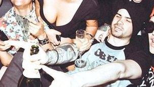 An image posted by Hunter Moore (on right, pointing, with hat) at a party