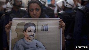 An anti-government protester holds a poster of human rights activist al-Khawaja 18/04/2012
