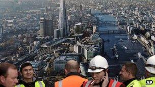 Workers stand in front of a picture of the Shard