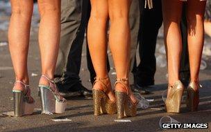 Ladies Day racegoers in platform heels at Aintree Grand National meeting