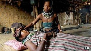 File photo of an Indian tribal woman attending to a malaria victim in the remote village of Bilaihum in the state of Tripur