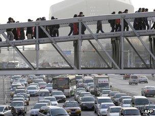 Pedestrians walk on a sky bridge in downtown Beijing (file photo)