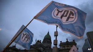 Supporters of an oil nationalization bill proposed by Argentina's President Cristina Fernandez holds up flags reading in Spanish "Fight and return YPF" outside Congress