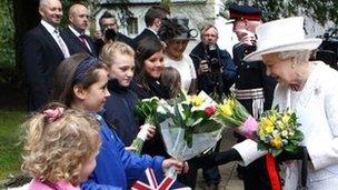 The Queen receives flowers from Georgie Seager, nine, as she leaves Llandaff Cathedral